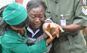 BOKO HARAM VICTIMS—A relation of one of the officers and soldiers killed in Borno, Yobe states and Unamid weeping during their burial at the National Military Cemetery in Abuja, yesterday.Photo: Abayomi Adeshida. 